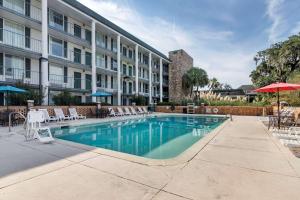 a pool with chairs and umbrellas in front of a building at Quality Inn At Town Center in Beaufort