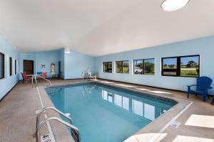 a large swimming pool with blue walls and windows at Quality Inn in Upper Sandusky