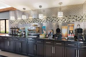 a kitchen with black cabinets and a counter top at Quality Inn in Upper Sandusky