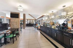 a restaurant with a counter and tables and chairs at Quality Inn in Upper Sandusky