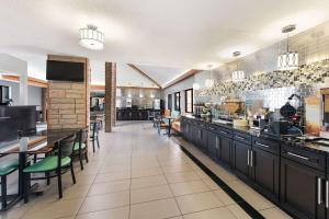 a restaurant with a counter and tables and chairs at Quality Inn Upper Sandusky in Upper Sandusky