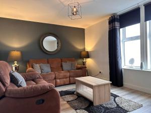 uma sala de estar com um sofá e uma mesa em Crown street getaway em Ayr