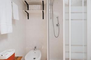 ein weißes Bad mit einer Dusche und einem WC in der Unterkunft B&B La Finestra Sul Campanile in Montecosaro