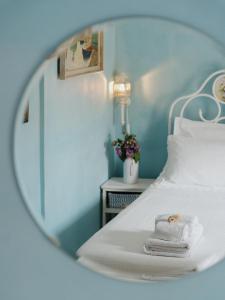 espejo reflejo de una cama con toallas en B&B La Finestra Sul Campanile, en Montecosaro