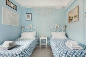 2 Betten in einem Zimmer mit blauen Wänden in der Unterkunft B&B La Finestra Sul Campanile in Montecosaro