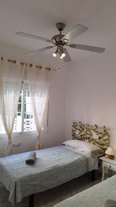 a bedroom with a ceiling fan and a bed at Sol y Mar I in Guardamar del Segura
