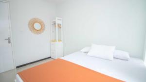 ein weißes Schlafzimmer mit einem orangefarbenen und weißen Bett in der Unterkunft Villa Fiorence Hill Premium Private Pool in Batu