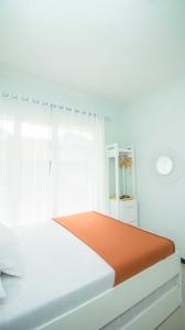 een witte slaapkamer met een bed en een raam bij Villa Fiorence Hill Premium Private Pool in Batu