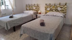 ein Schlafzimmer mit zwei Betten mit Hüten darauf in der Unterkunft Sol y Mar I in Guardamar del Segura