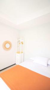 - une chambre blanche avec un lit et un miroir dans l'établissement Villa Fiorence Hill Premium Private Pool, à Batu
