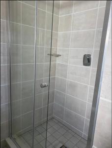 a shower with a glass door in a bathroom at Taina Apartment @ Green Creek in Pretoria +7 photos