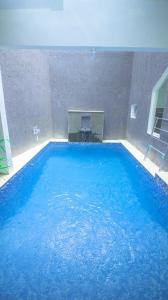 een groot zwembad met blauw water in een gebouw bij Villa Fiorence Hill Premium Private Pool in Batu