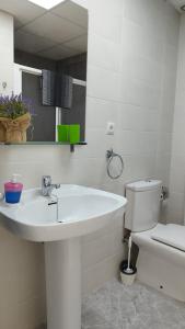 a white bathroom with a sink and a toilet at Sol y Mar I in Guardamar del Segura