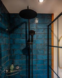 a bathroom with a blue brick wall and a shower at Coorie View in Kilmore