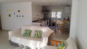 ein Wohnzimmer mit einem Sofa und einer Küche in der Unterkunft Sol y Mar I in Guardamar del Segura