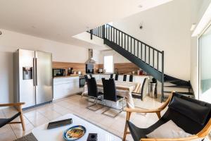 Il comprend une cuisine et un salon avec un escalier en colimaçon. dans l'établissement Ravissante maison 3* avec jacuzzi proche lac, à Biscarrosse