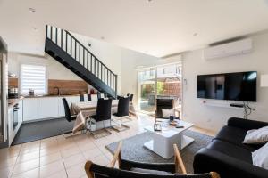 un salon avec un canapé et une table et une cuisine dans l'établissement Ravissante maison 3* avec jacuzzi proche lac, à Biscarrosse