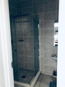 a shower with a glass door in a bathroom at Taina Apartment @ Green Creek in Pretoria