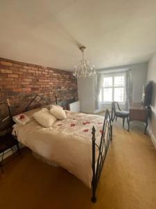um quarto com uma cama grande e uma parede de tijolos em Chandeliers 6 em Shrewsbury