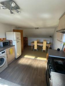 a kitchen with a table and a refrigerator and a table and chairs at Chandeliers 6 in Shrewsbury