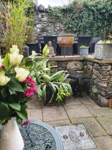 a patio with a table and chairs and flowers at The Retreat in Carlingford