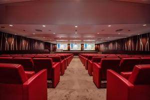 un cine vacío con sillas rojas en una habitación en Krystal Palace Douala, en Douala 81 fotos más