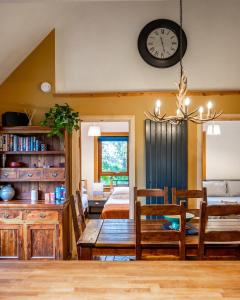 a dining room and living room with a clock on the wall at Coorie View in Kilmore