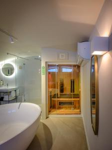 a bathroom with a white tub and a sink at FINCH Boutique Hotel, downtown in Deventer