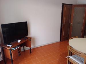 ein Wohnzimmer mit einem TV und einem Tisch mit einem Tisch in der Unterkunft Risveglio al Sole in Ragusa