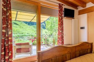 a bedroom with a bed and a large glass window at Hotel Calvi-Ristorante Mainor in Vittorio Veneto