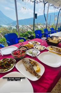 uma mesa com pratos de comida numa toalha de mesa vermelha em 5 Stinet em Koman