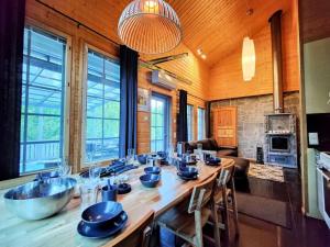 eine große Küche mit einem langen Holztisch in einem Zimmer in der Unterkunft Himos Virpi 8 hlö mökki porealtaalla, ei lisäkuluja! in Jämsä