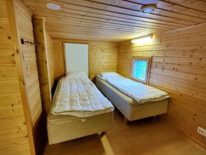 1 Schlafzimmer mit 2 Betten in einer Holzhütte in der Unterkunft Himos Virpi 8 hlö mökki porealtaalla, ei lisäkuluja! in Jämsä