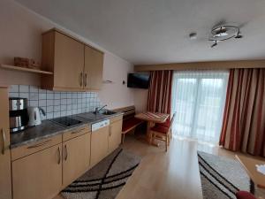 a kitchen with wooden cabinets and a table in front of a window at Haus Tanja in Längenfeld