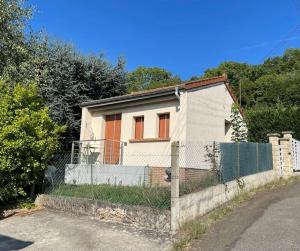 a white house with orange doors and a fence at Maison avec sous sol indépendant et parking à 2km de Versailles in Buc