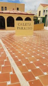 a sign on a brick sidewalk in front of a building at CABO PARAISO in Costa de Antigua