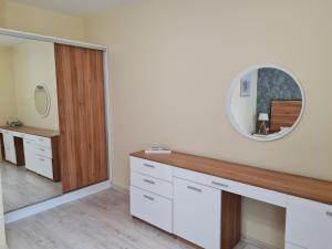 a bathroom with a vanity and a mirror at Apartments Ilarion in City Center in Varna City