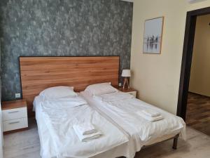 um quarto com uma cama grande e uma cabeceira em madeira em Apartments Ilarion in City Center em Varna City