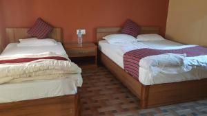 duas camas sentadas uma ao lado da outra num quarto em Gharbas Homestay - Sauraha em Sauraha
