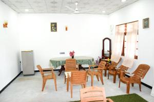 uma sala de jantar com mesa e cadeiras em Tharaka Homestay em Weligama