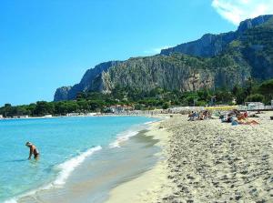 a group of people on a beach in the water at AR Palace Hotel - Palermo in Isola delle Femmine