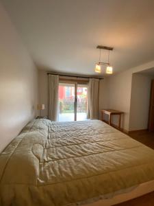una camera da letto con un letto grande e una finestra di Departamento Centrico a San Martín de los Andes