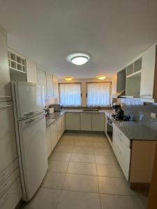 una cucina con elettrodomestici bianchi e frigorifero bianco di Departamento Centrico a San Martín de los Andes