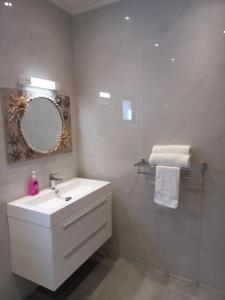 bagno con lavandino bianco e specchio di RIVERSIDE RETREAT (SEYCHELLES) a Mahe