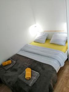 een slaapkamer met een groot bed en handdoeken bij NIKAS Apartman in Donji Milanovac
