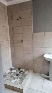 W łazience znajduje się prysznic i umywalka. w obiekcie The Unit Party House w mieście eNyalungu