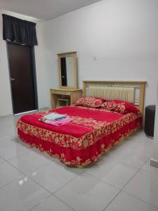 um quarto com uma cama com uma colcha vermelha em Juliana Homestay em Jitra
