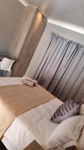 1 dormitorio con 1 cama grande y ventana en The Unit Party House, en eNyalungu