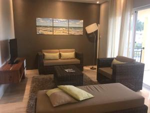 a living room with a couch and chairs and a television at 2 bedrooms appartement at Flic en Flac 100 m away from the beach with shared pool furnished terrace and wifi in Flic-en-Flac