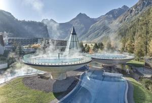two hot springs in a resort with mountains in the background at Haus Tanja in Längenfeld